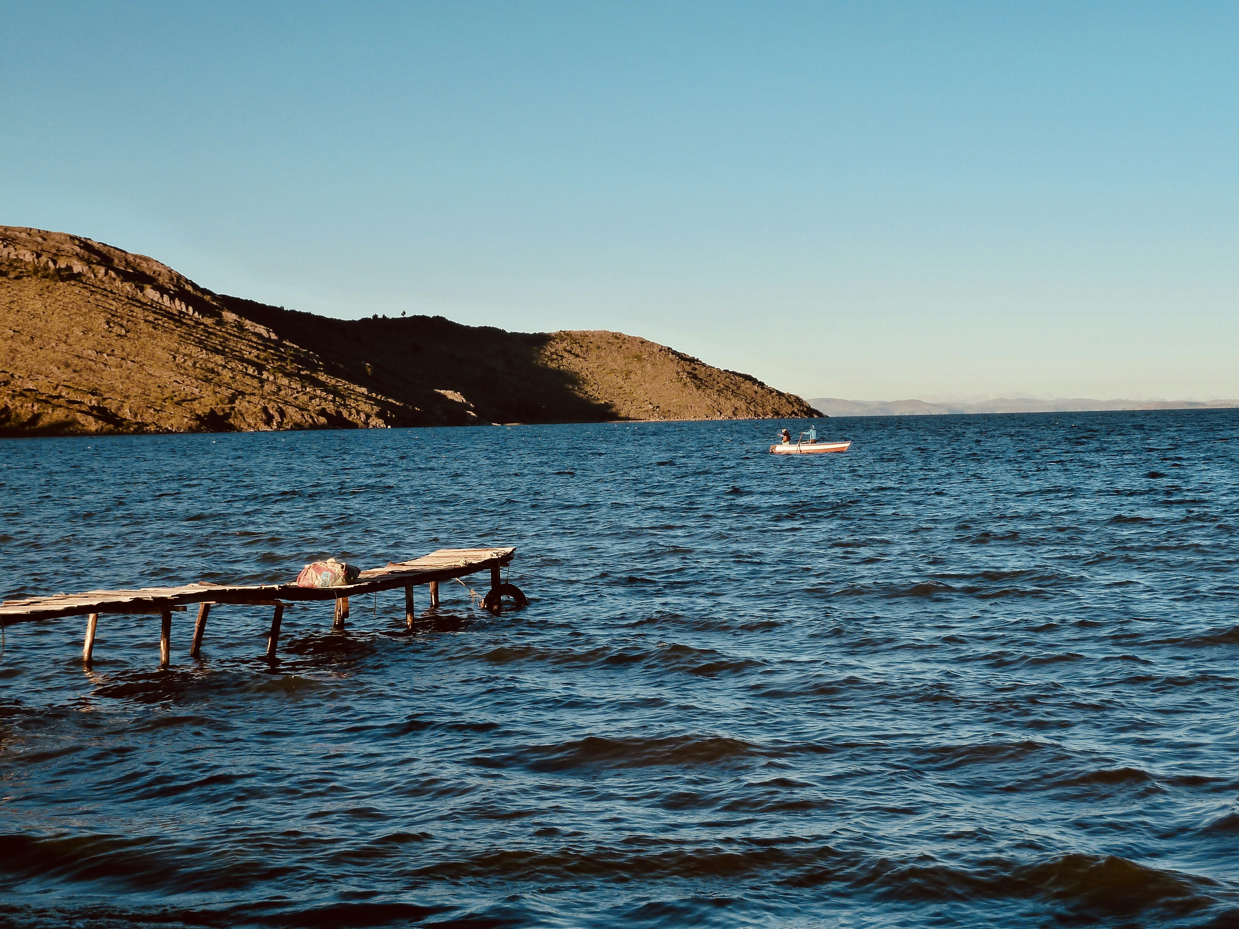 white and brown boat on sea during daytime, Lake Titicaca Capachipa Peru