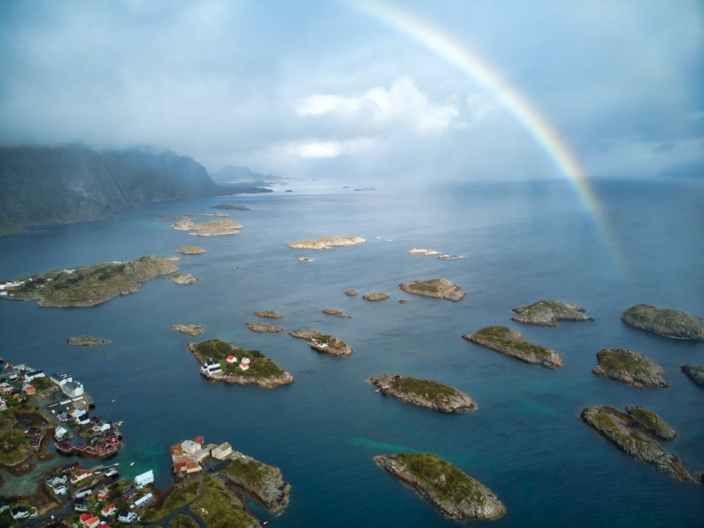 a rainbow over a body of water with small islands