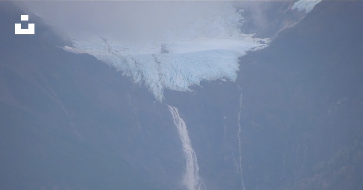 Green trees near snow covered mountain during daytime photo Free