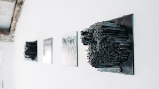a white wall with black artwork hanging on it