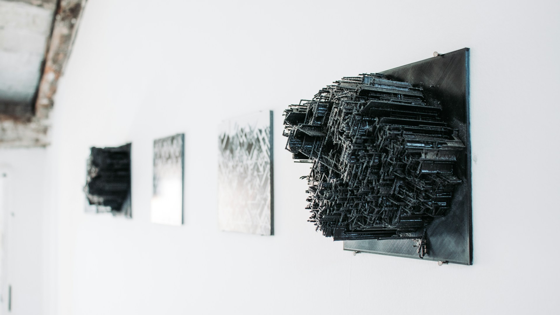 a white wall with black artwork hanging on it