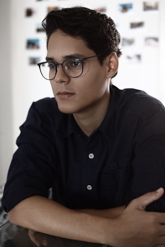 man in black button up shirt wearing black framed eyeglasses