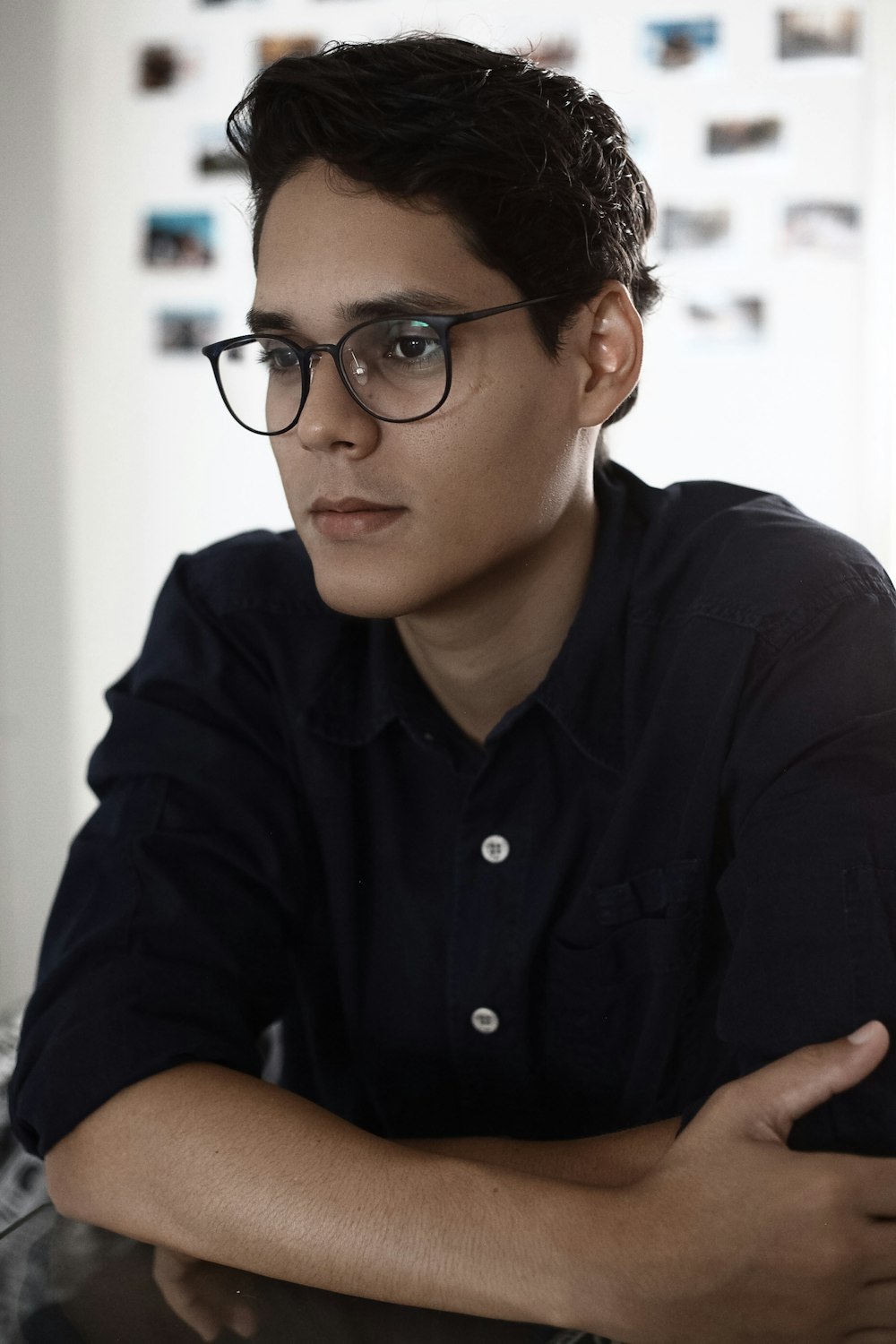 Homme en chemise noire boutonnée portant des lunettes à monture noire