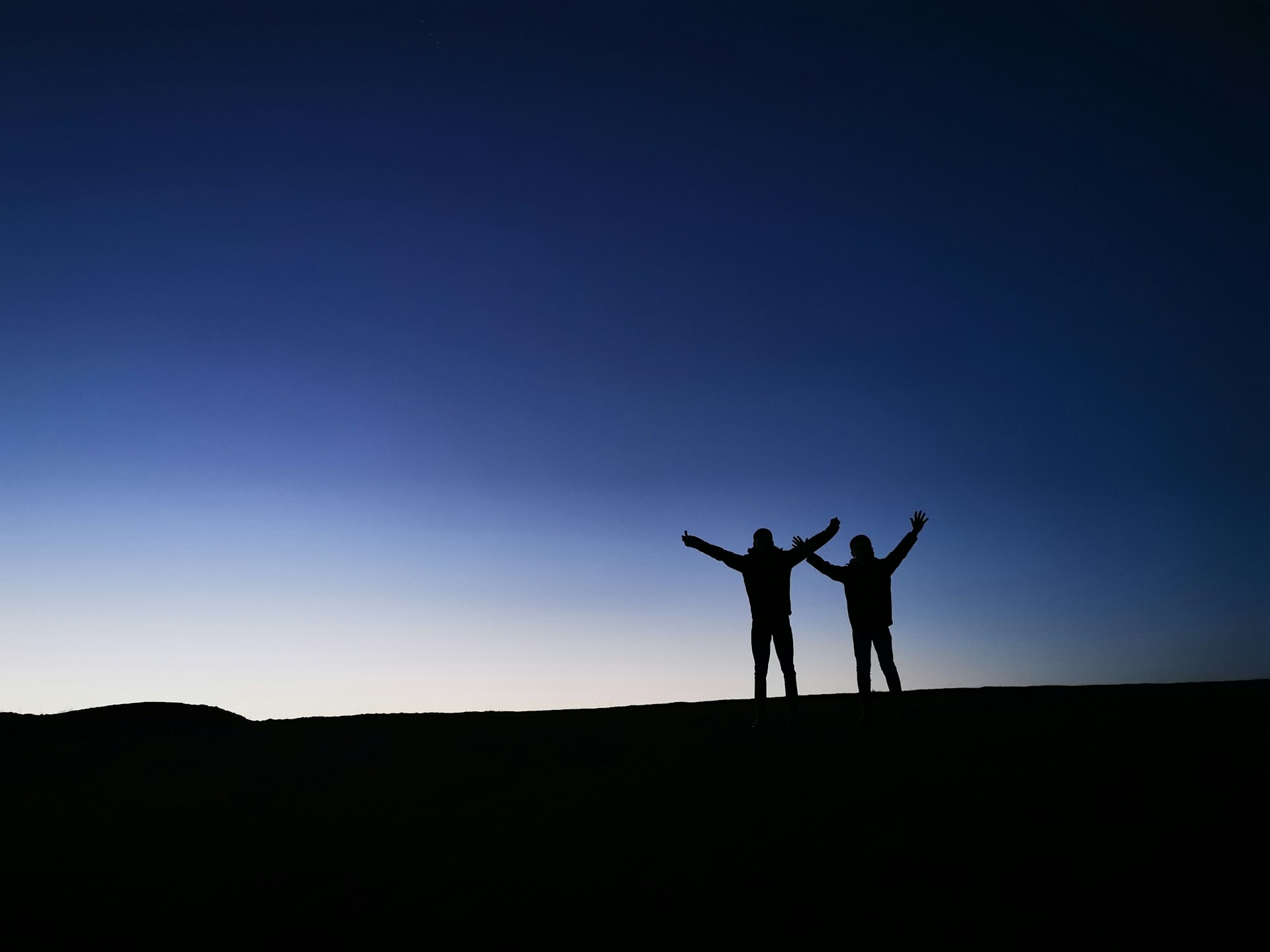 a couple of people standing on top of a hill