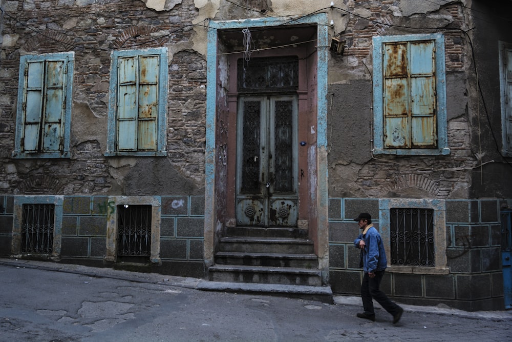 a man walking down a street past a building