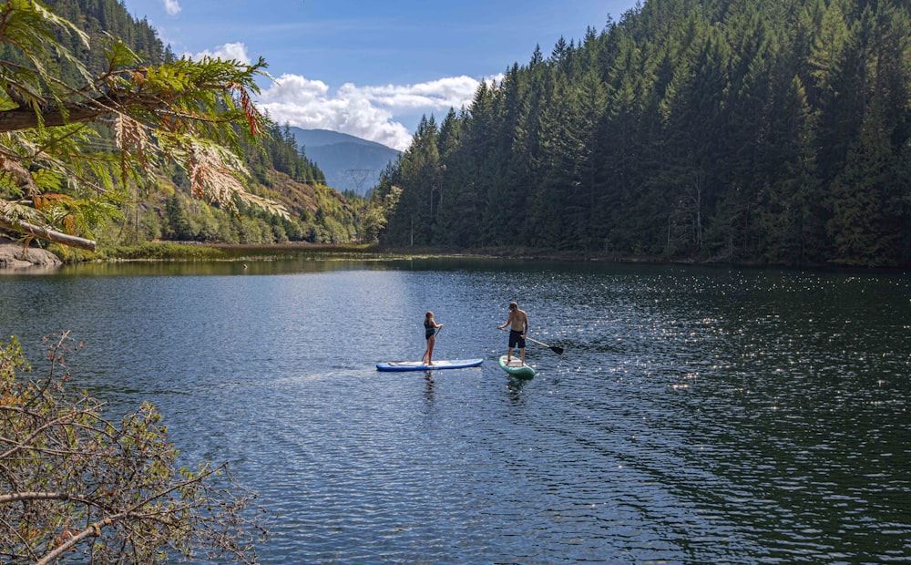 a couple of people on a paddle board in the water