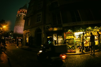 Evening market scene with Casa Martorana’s triporteur illuminated under warm lights.