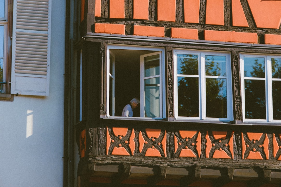 man in white shirt standing in front of window