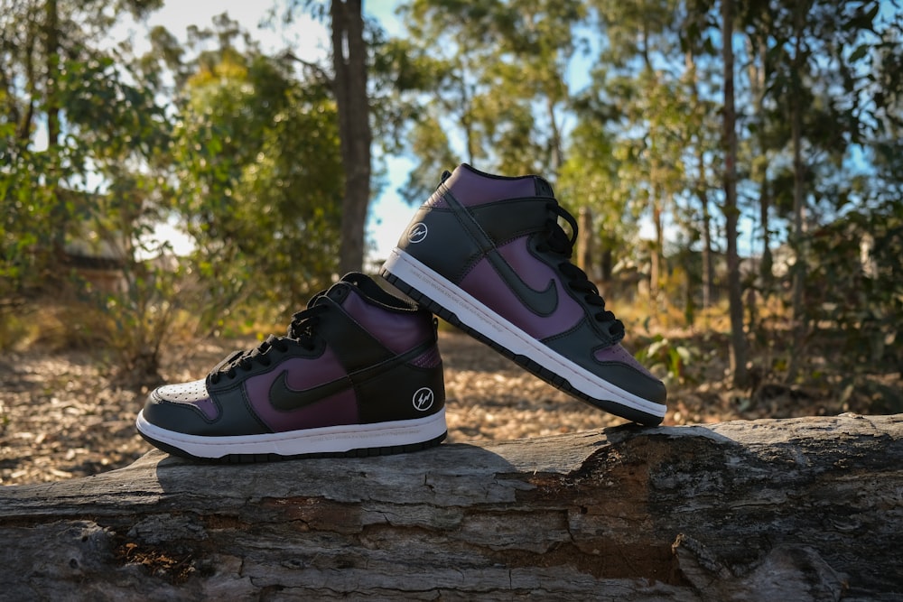 a pair of shoes sitting on top of a log