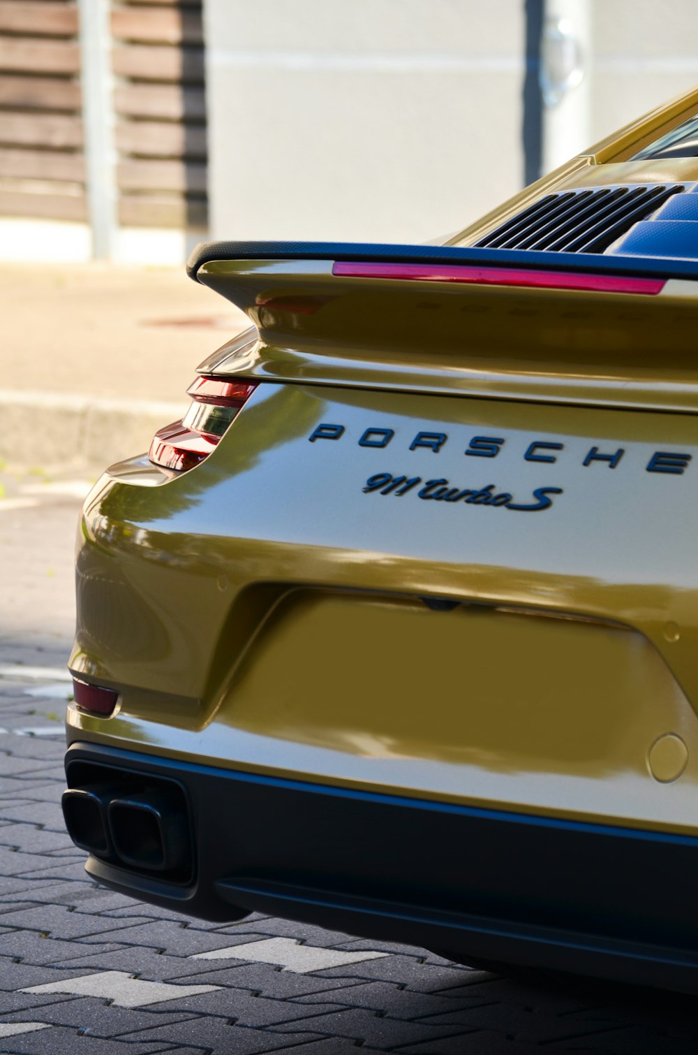 the rear end of a porsche car parked on the side of the road