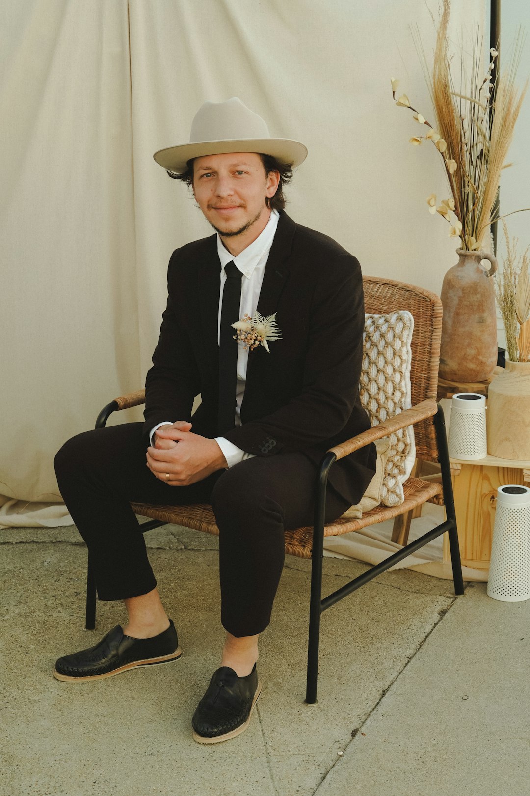 man in black suit sitting on brown wooden armchair