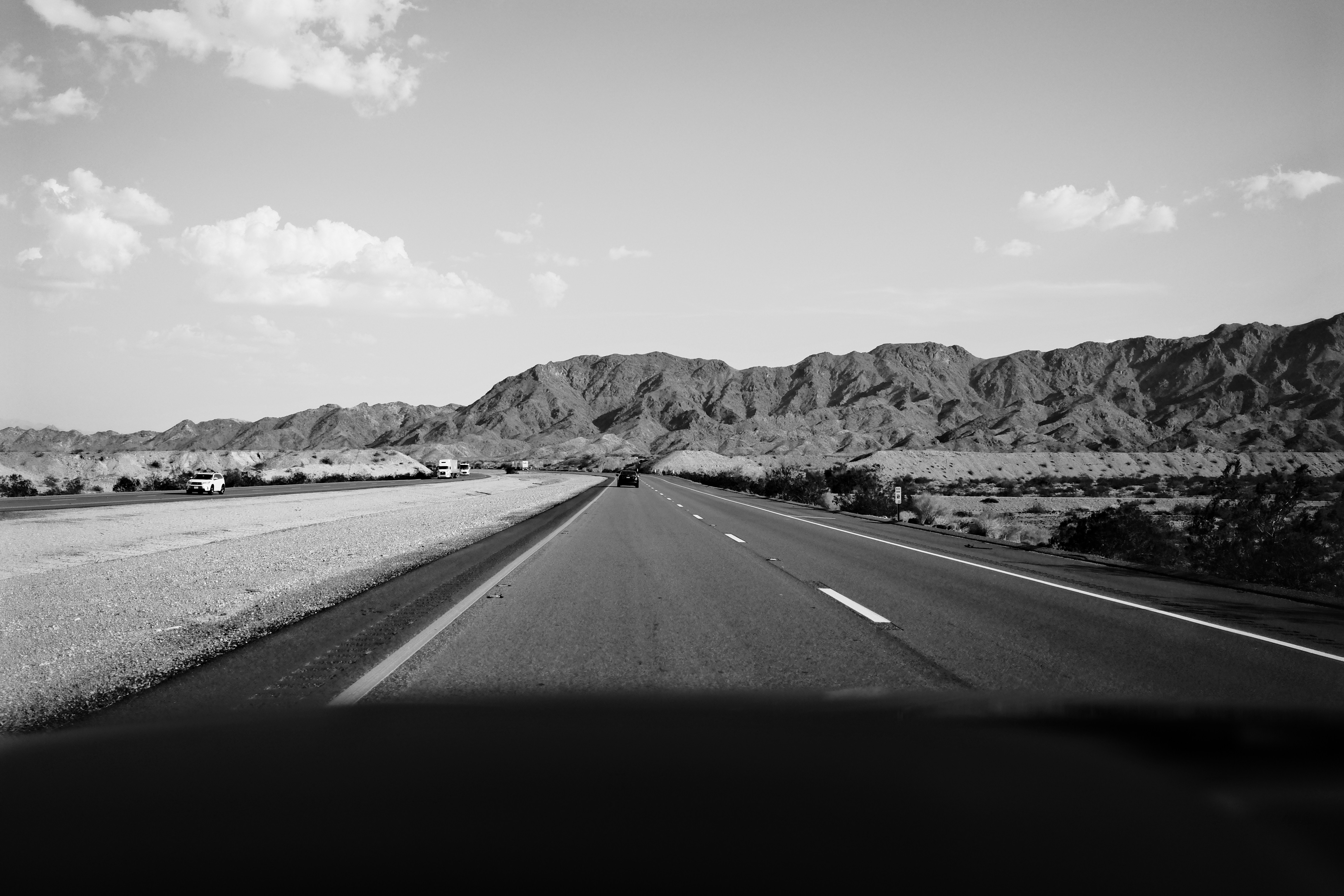 grayscale photo of road near mountain, Mojave Desert Mountains