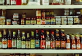 assorted bottles on brown wooden shelf