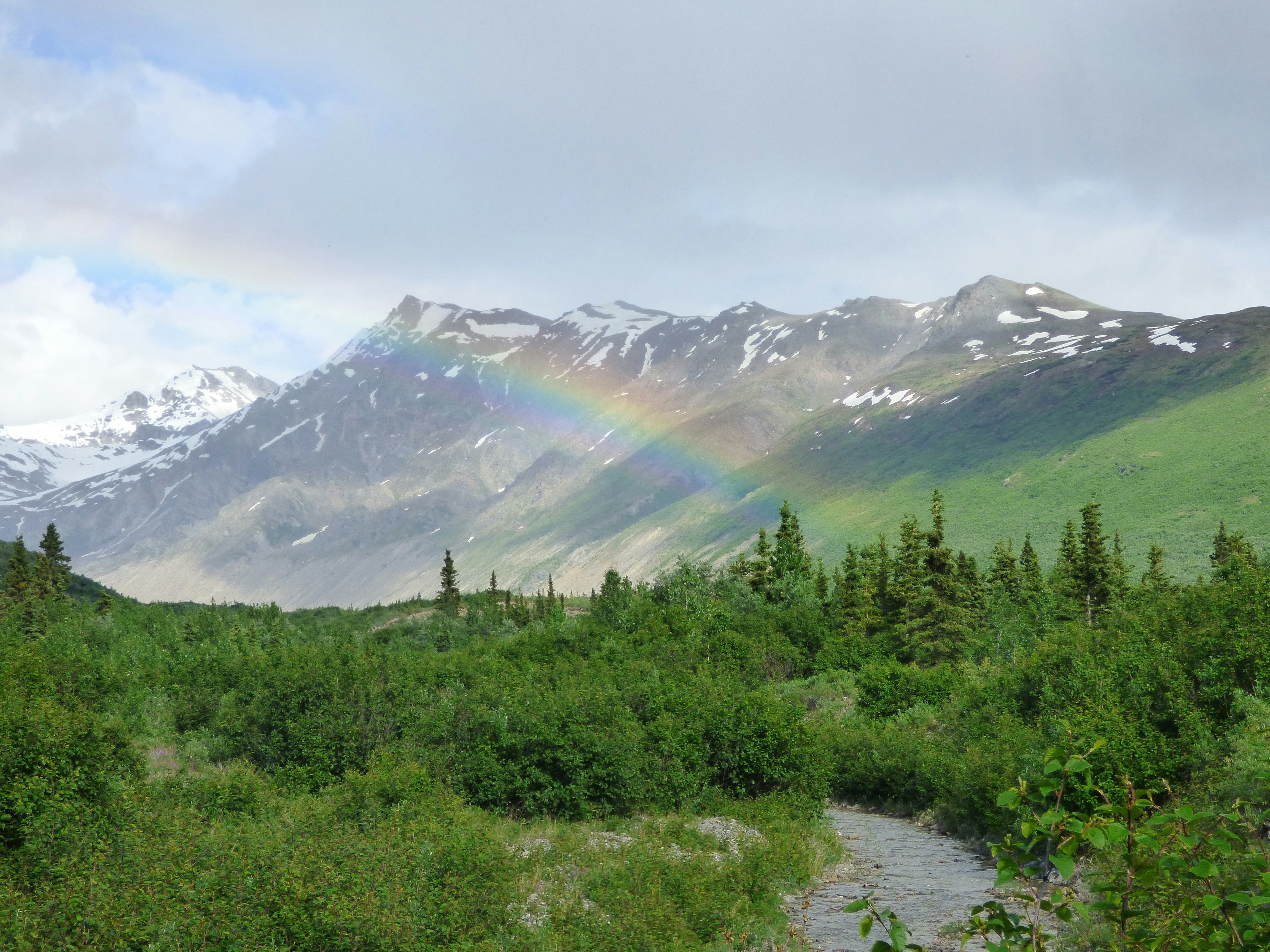 Rainbow over a river near a mountain in Alaska