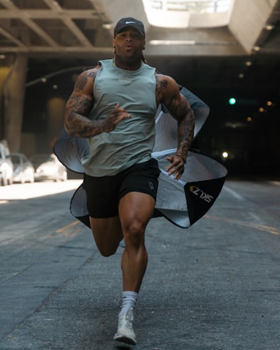 man in gray crew neck t-shirt and black shorts sitting on black skateboard during daytime
