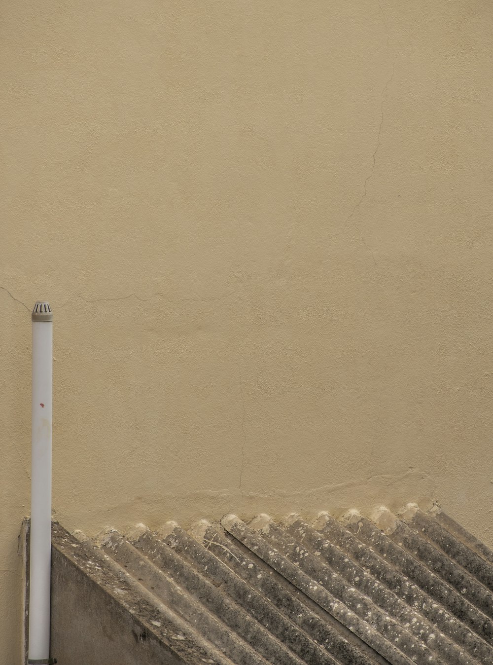 tubo di metallo bianco vicino al muro marrone