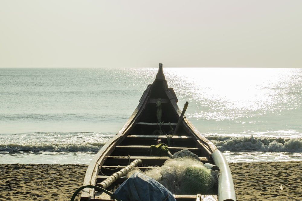 brown wooden boat on beach during daytime