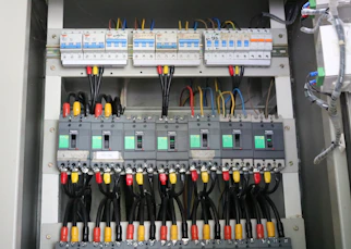 Workers engaged in detailed electrical panel setup.