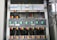 A detailed view of an electrical panel displaying a neatly arranged set of circuit breakers and wiring. The panel includes multiple switches, each labeled with specific codes, and wires of various colors connecting to them. The setup is orderly, with cables aligned and organized through plastic holders.