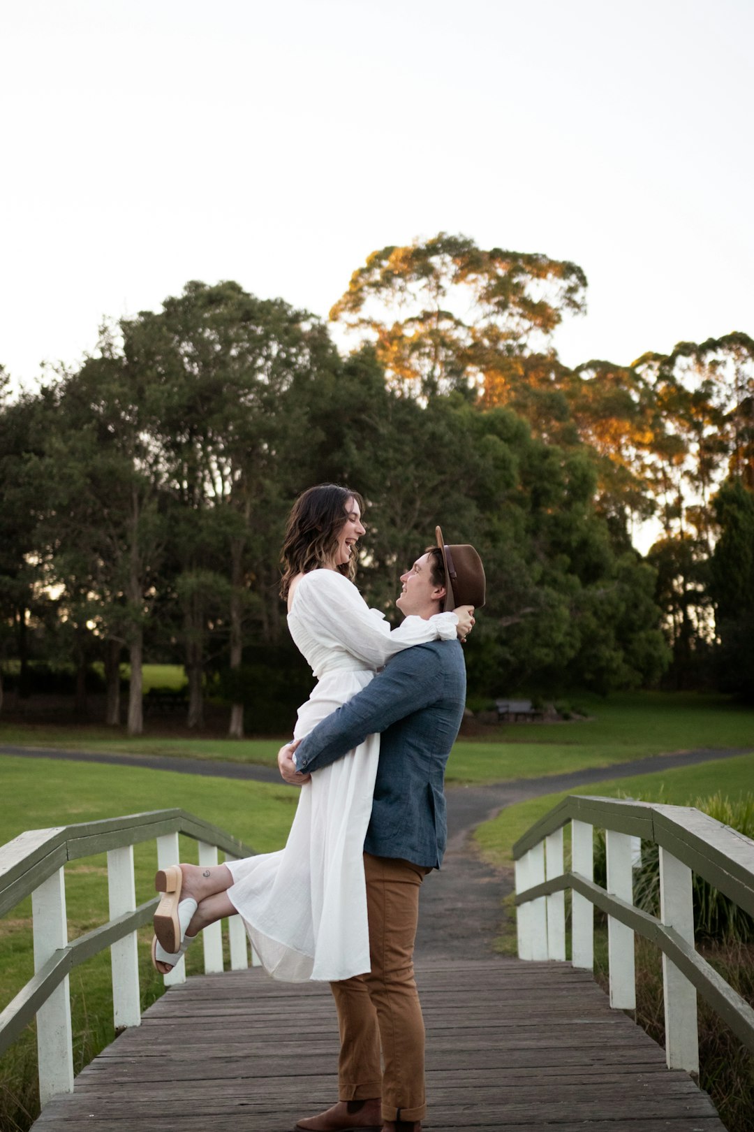 man in white dress shirt kissing woman in white dress during daytime