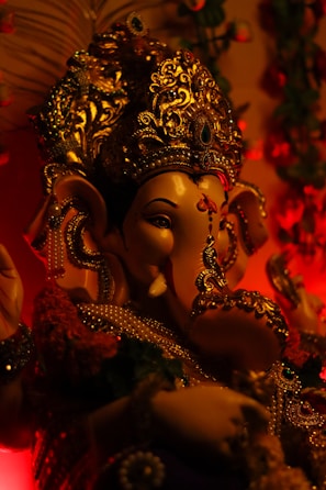 Close-up of a finely detailed brass Lord Ganesha statue glowing softly in warm light.