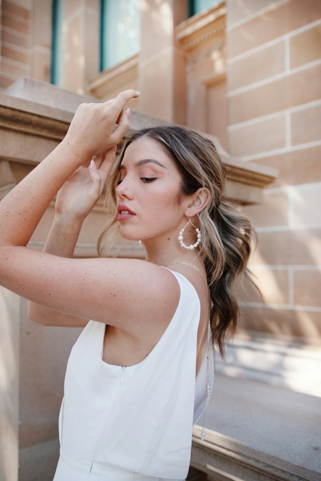 woman in white tank top holding her hair