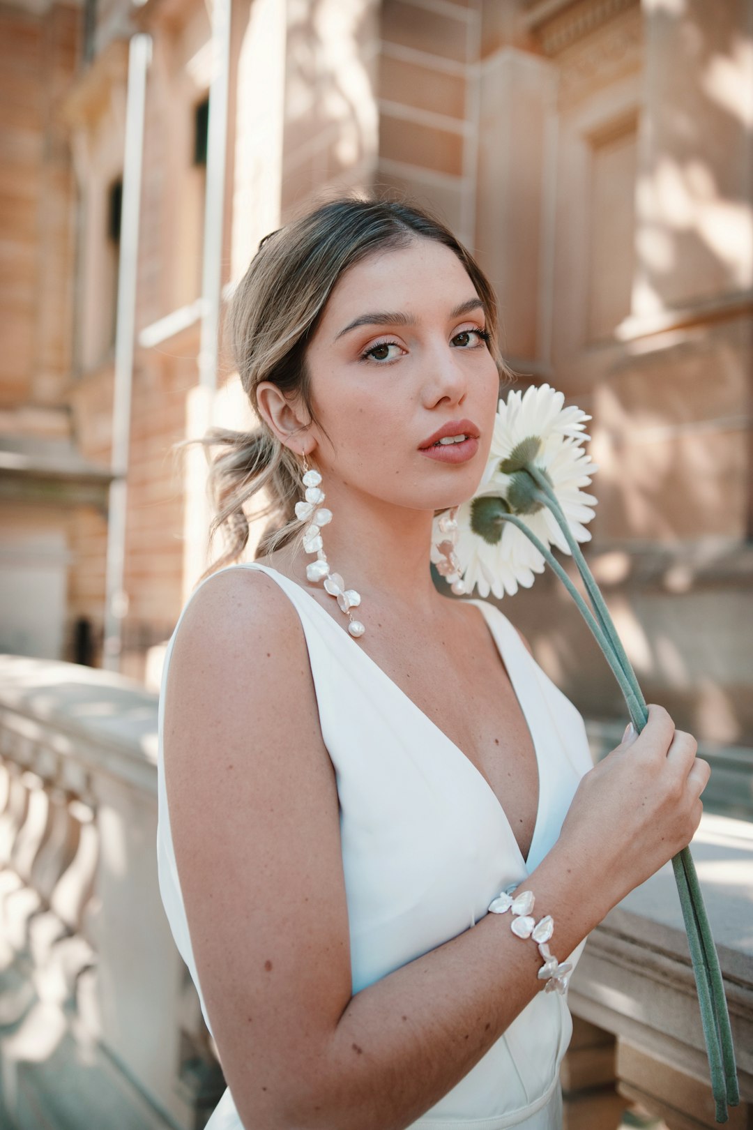 woman in white tank top holding white flower