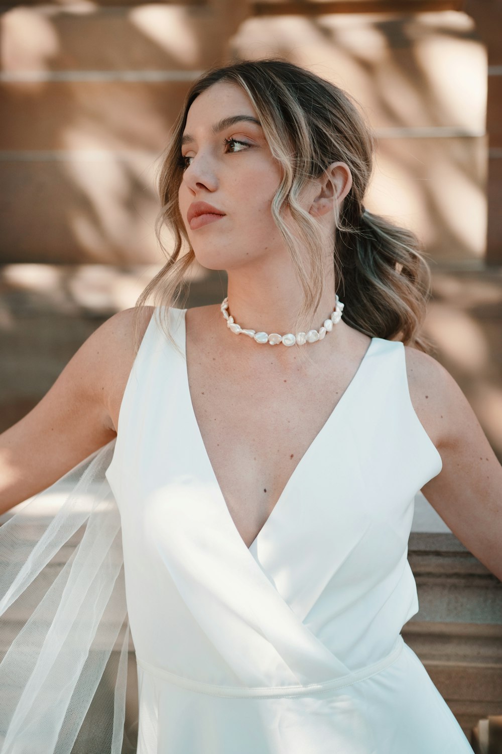 woman in white sleeveless dress wearing silver necklace
