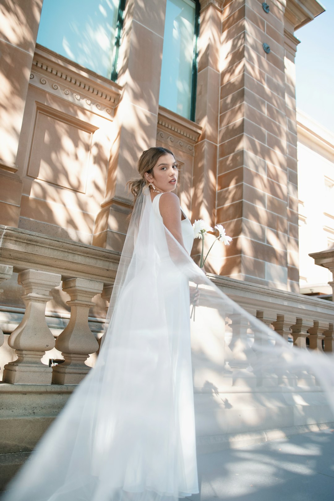 woman in white wedding dress standing on stairs