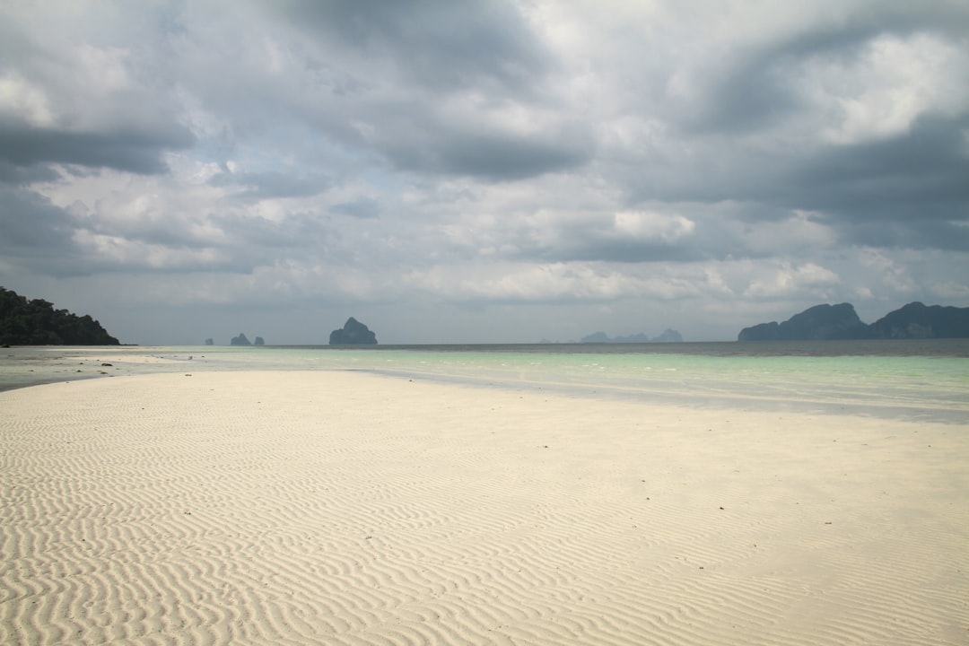 white sand beach under cloudy sky during daytime