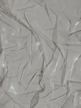 Crinkled and partially transparent plastic sheet, with light reflecting off its surface.
