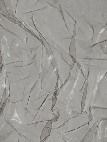 Sheets of shiny PVC plastic material displayed in different thicknesses and hues.