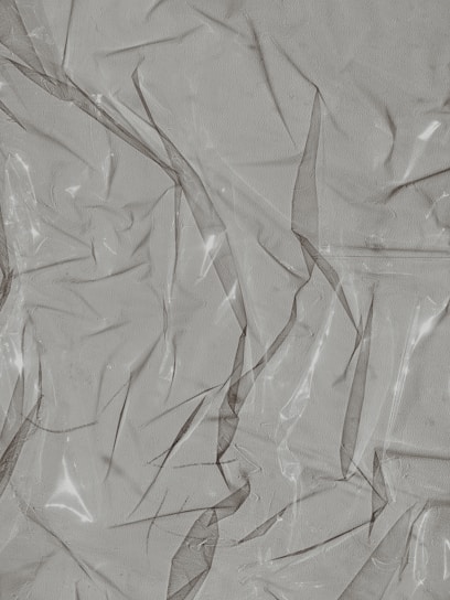 Crinkled and partially transparent plastic sheet, with light reflecting off its surface.