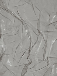 Crinkled and partially transparent plastic sheet, with light reflecting off its surface.