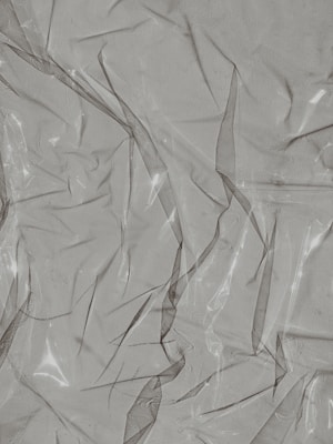 Crinkled and partially transparent plastic sheet, with light reflecting off its surface.