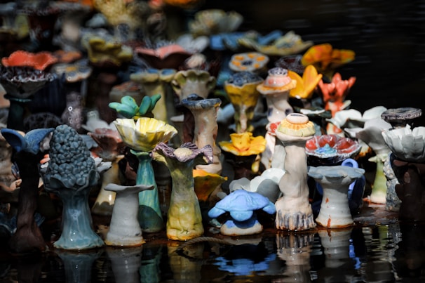 A collection of unique ceramic sculptures featuring natural curves and bold blue and red accents.