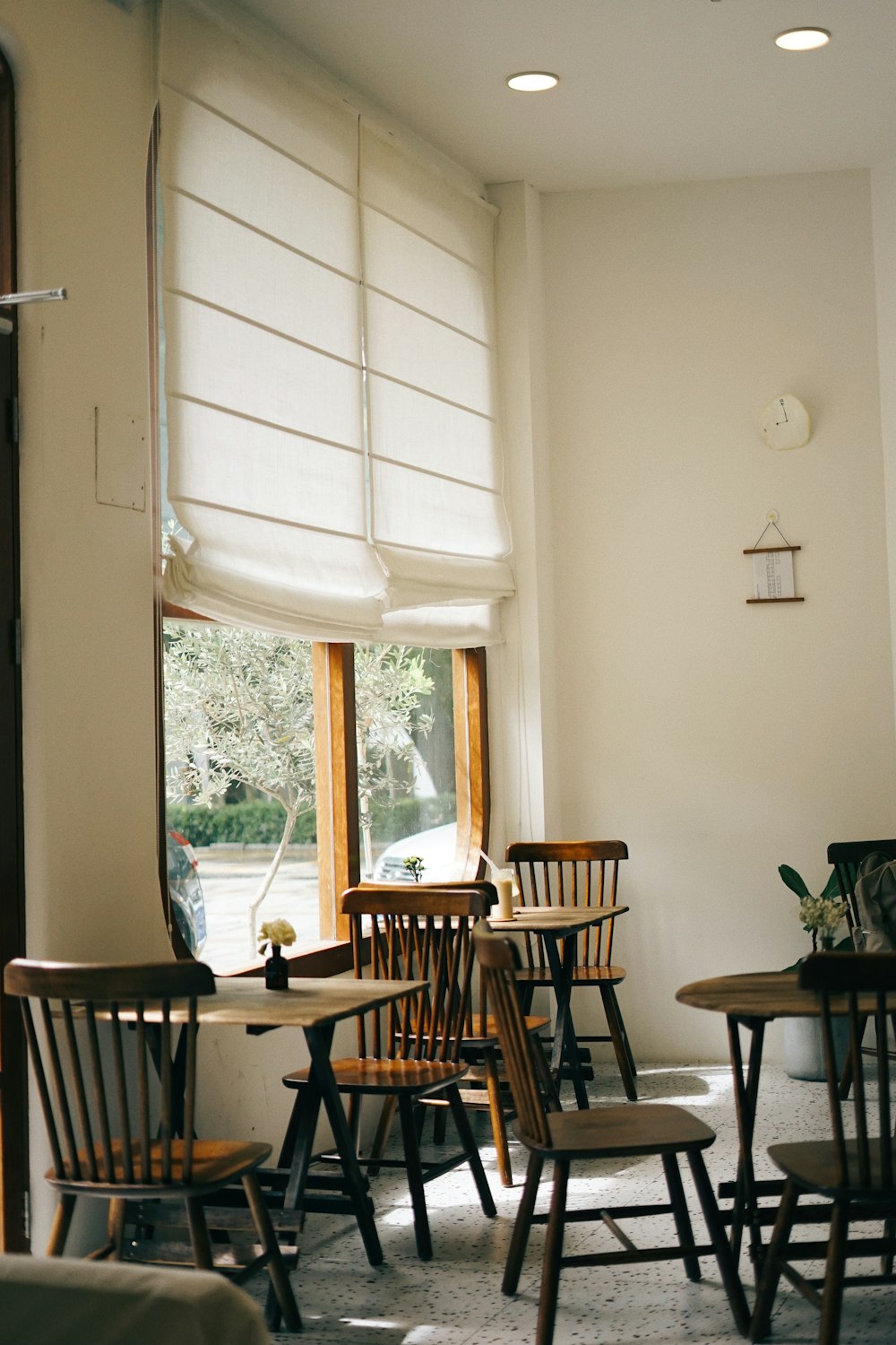 brown wooden table and chairs near window