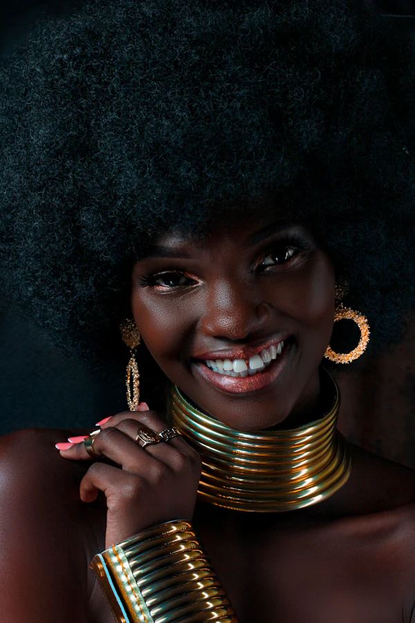 Mulher sorrindo com brincos e colares dourados