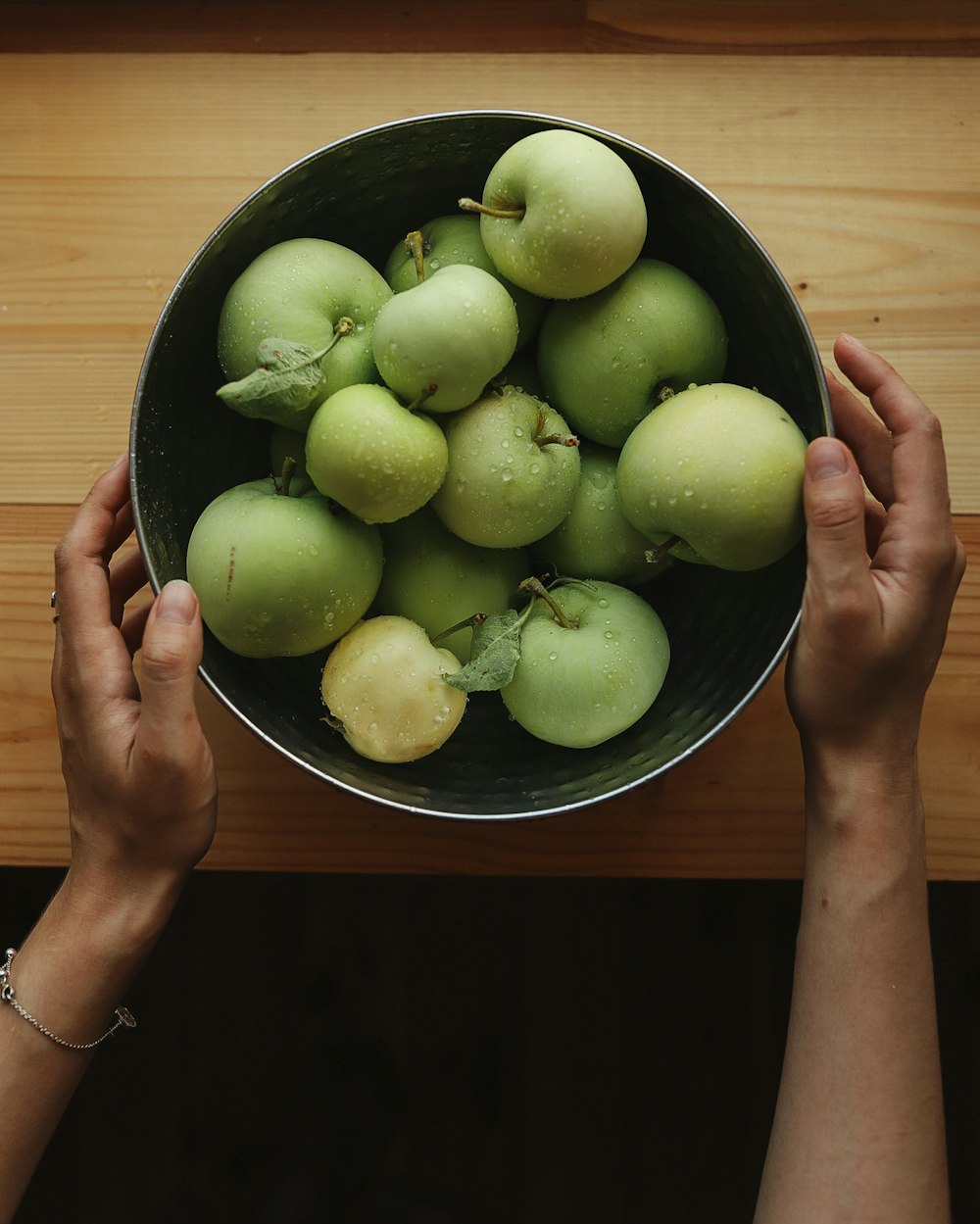 green round fruits on black ceramic bowl