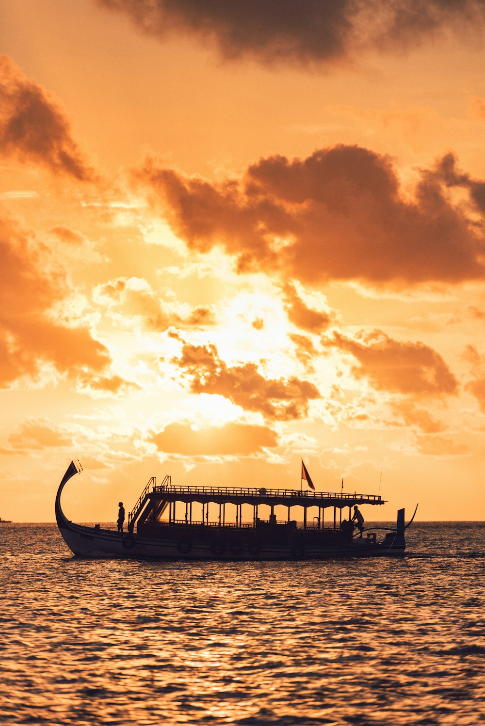 silhouette of boat on sea during sunset