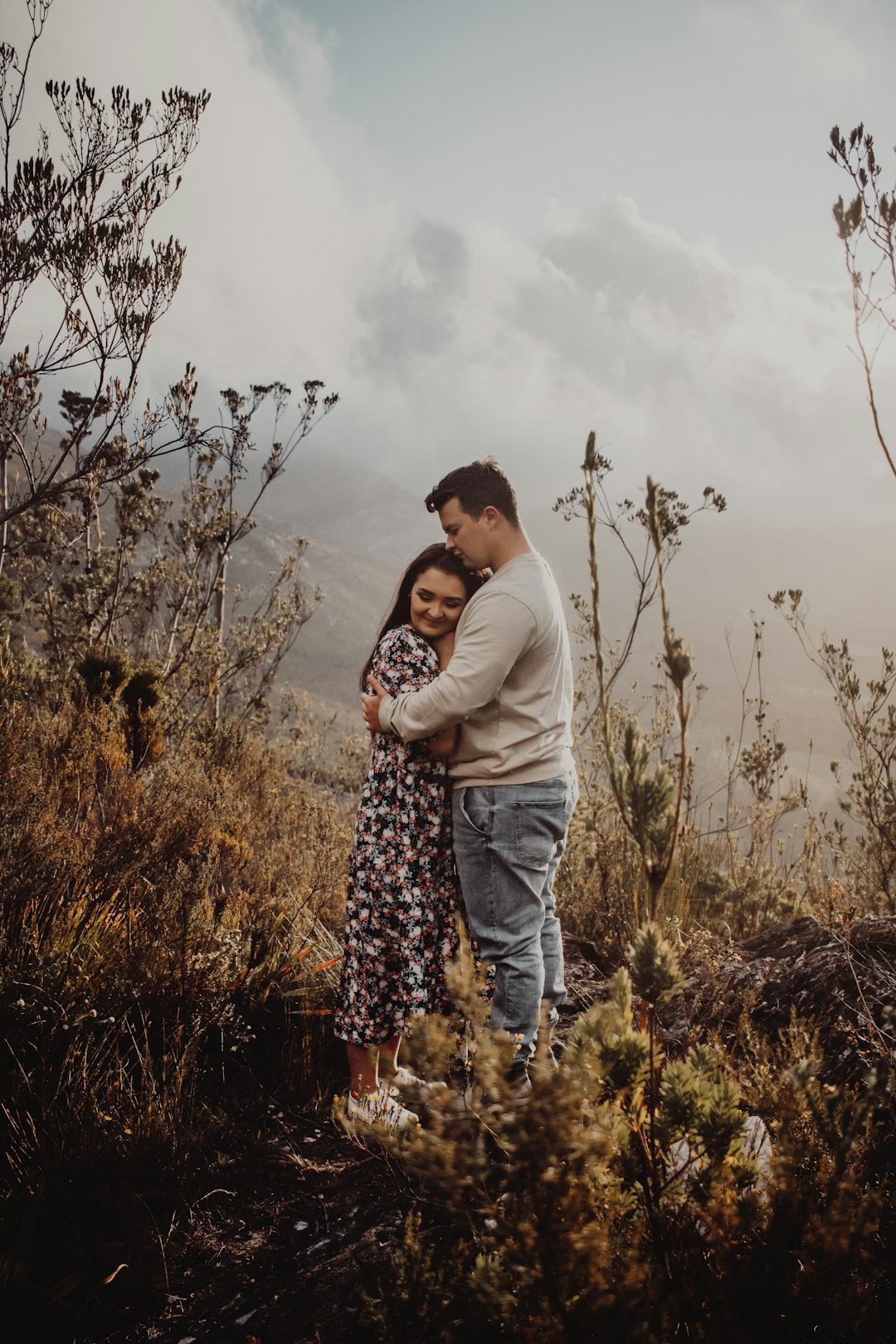 man and woman kissing on brown grass field during daytime