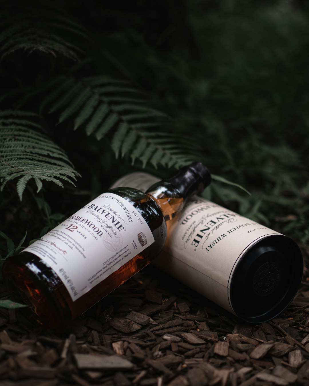 two brown glass bottles on green leaves