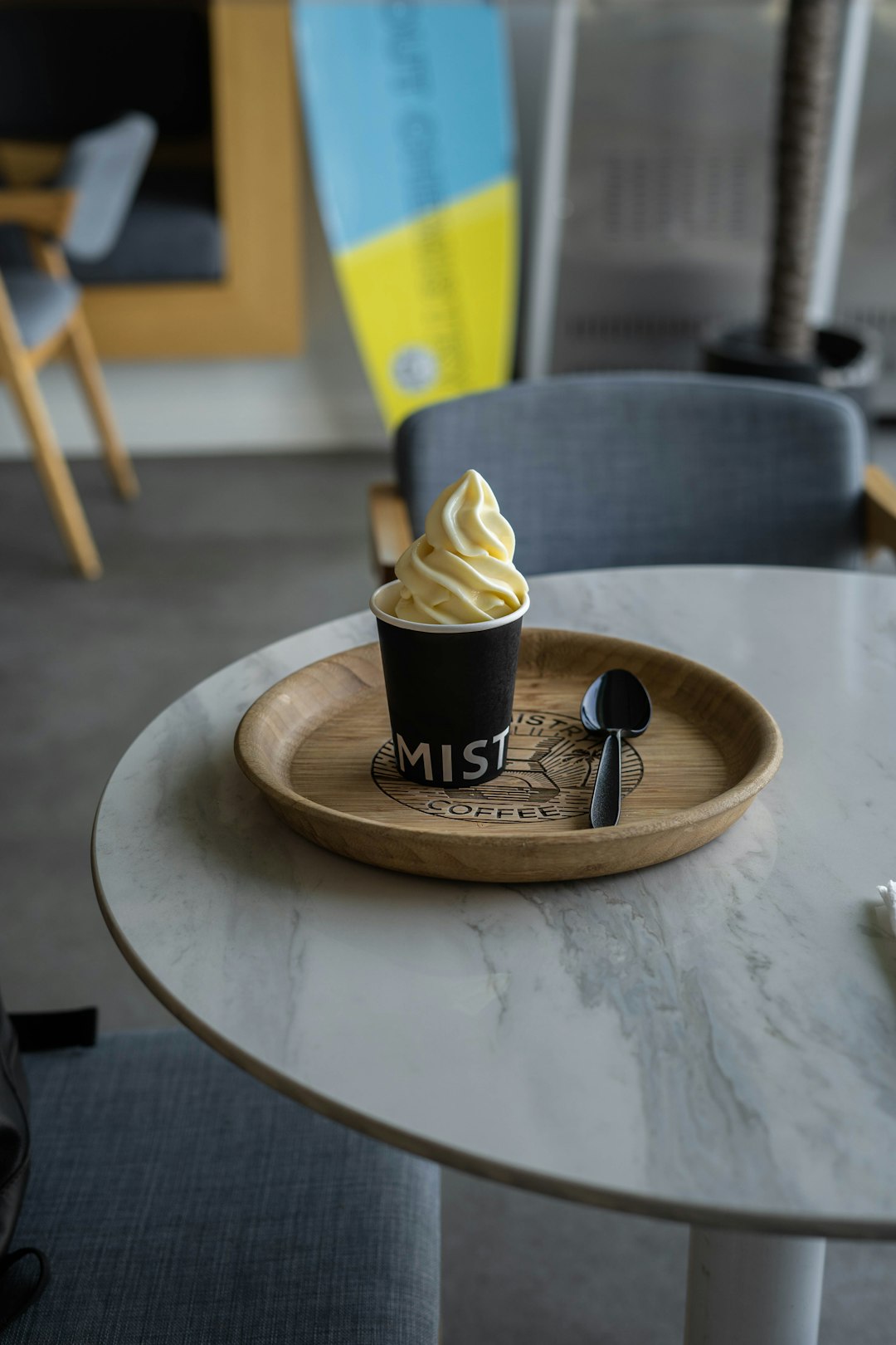 black and white disposable cup on brown wooden round table