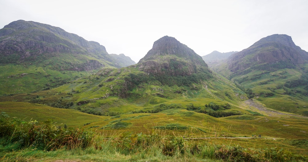 green grass field near mountain during daytime