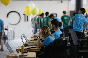 a group of people working on laptops in a room