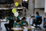 a group of people sitting at desks working on laptops