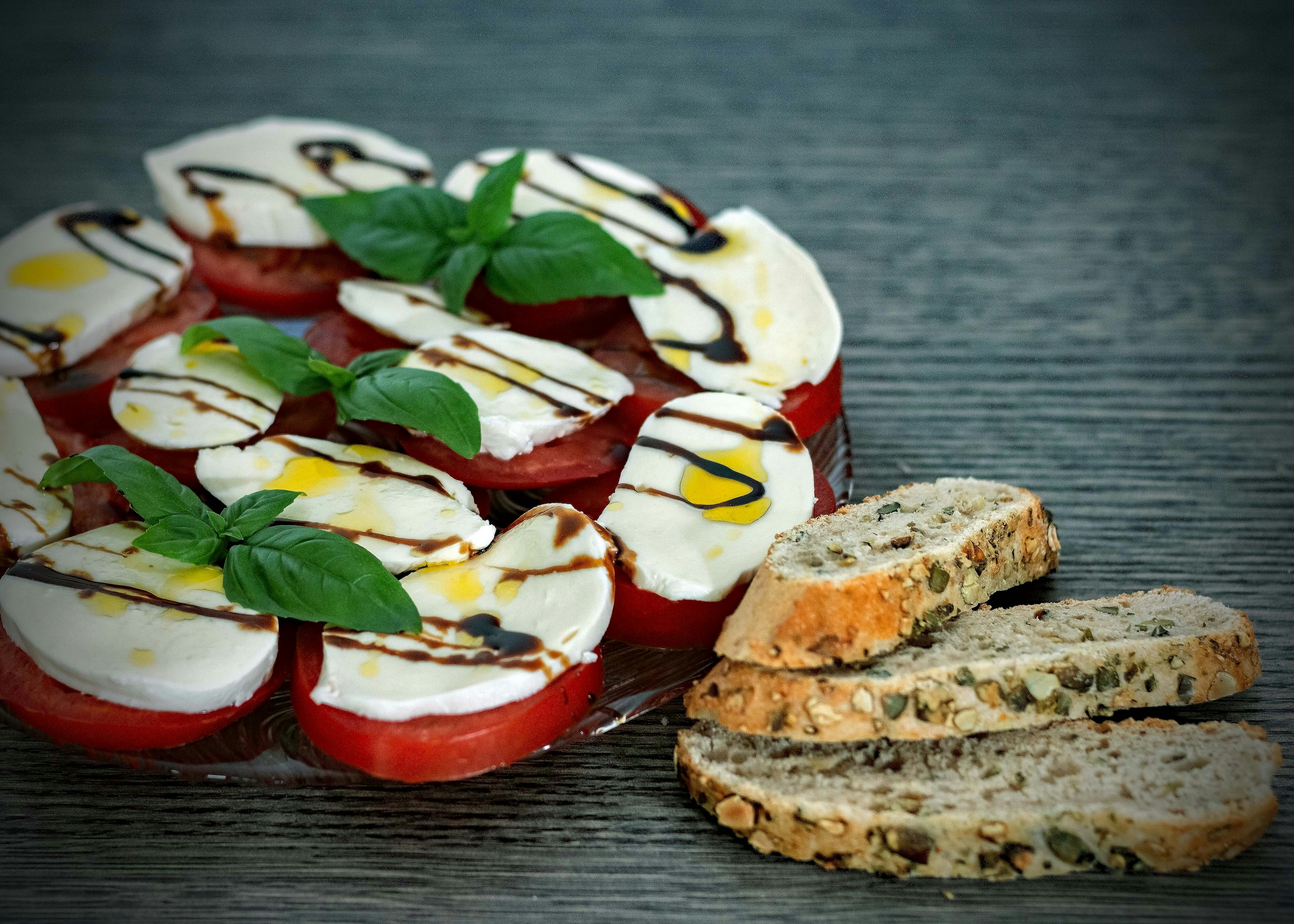 Pizza caprese con mozzarella bianca e basilico verde su sfondo rustico