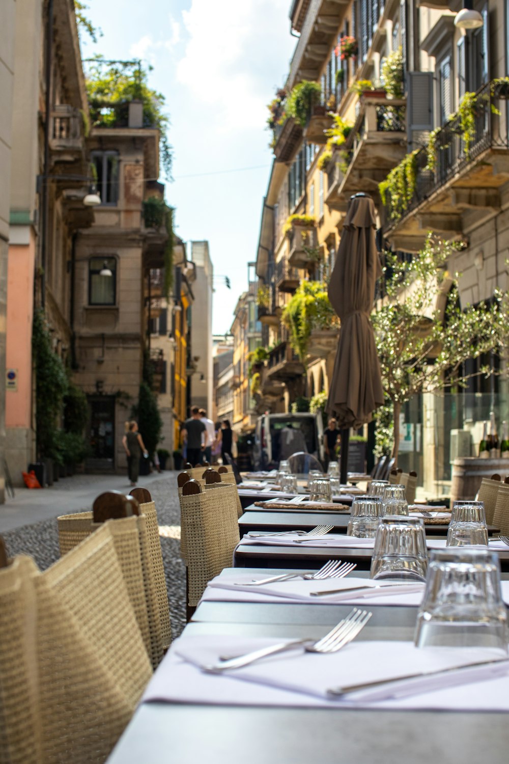 brown wicker chairs and table on street during daytime