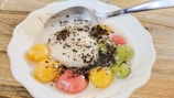 Elegant dessert plate featuring mango sticky rice with a sprinkle of toasted sesame seeds.