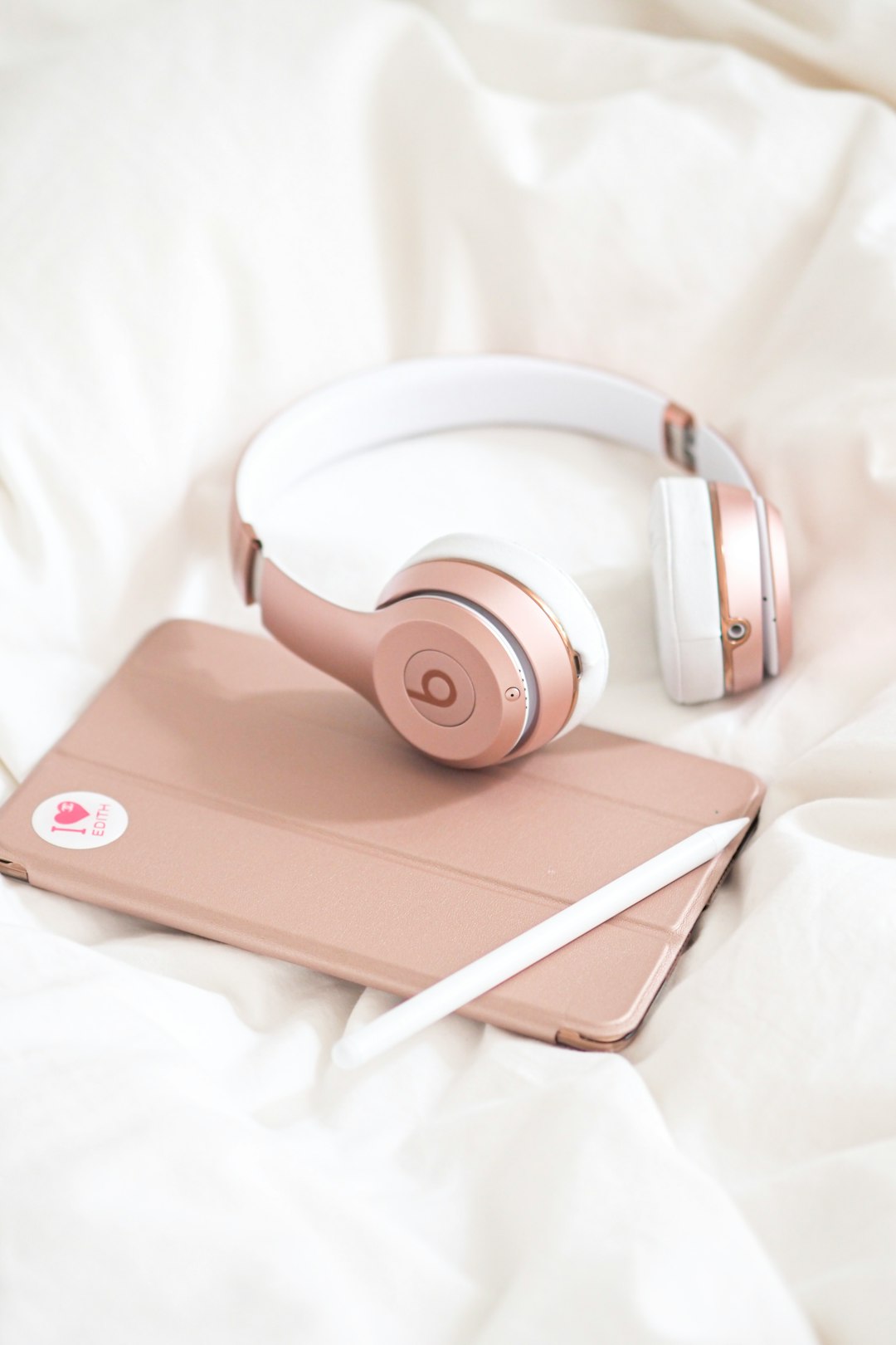 brown and white beats by dr dre headphones on white ipad